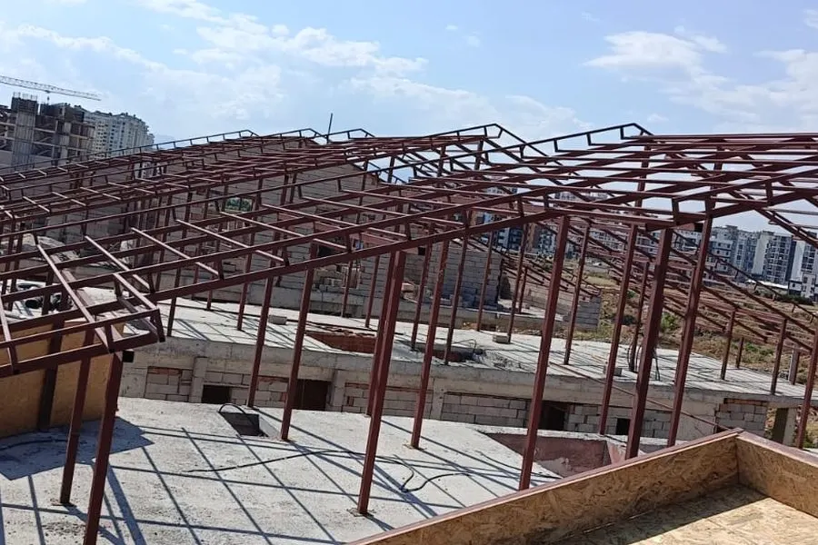 Kaba yapısı süren bir alanın üzerine kurulmuş geniş açıklıklı çelik çatı düzeni
