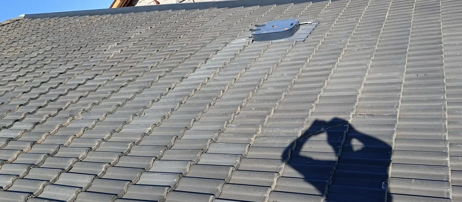 Eğimli kiremit yüzeyin ortasına oturtulmuş küçük metal havalandırma kapağı